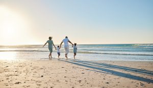 A family enjoying the sun and sea by the shoreline.